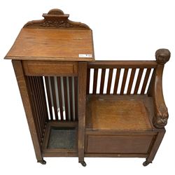 Victorian carved oak hall bench, raised shaped pediment carved with acorns and oak leaves, hinged lid over stick and umbrella stand with drip tray, fitted with a series of vertical rails, hinged and panelled box seat, carved with grotesque masks 