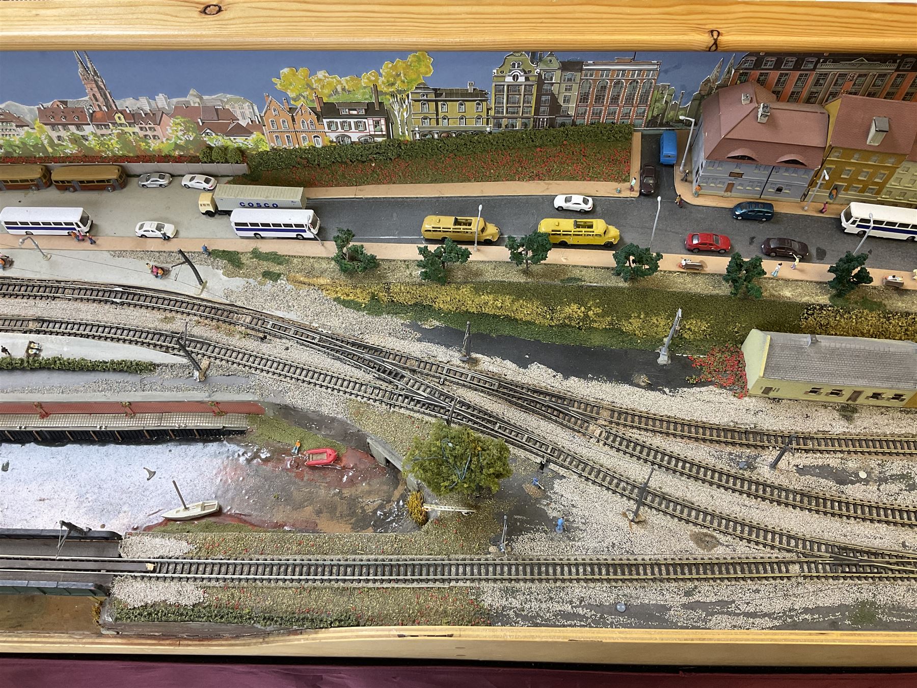 'Z' gauge continental scenic layout with folding legs, various loops of track and sidings with overhead cables, buildings including water tower, tunnels, roads with motor vehicles and figures, trees, haven with boats, backdrop diving wall hiding control units 150 x 50cm
