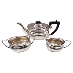 1930s silver three piece tea service, comprising teapot, milk jug and twin handled open sucrier, each of oval bellied form, with a band of engraved foliate decoration to body, the teapot with Bakelite handle and finial, hallmarked Harrison Fisher & Co, Sheffield 1936