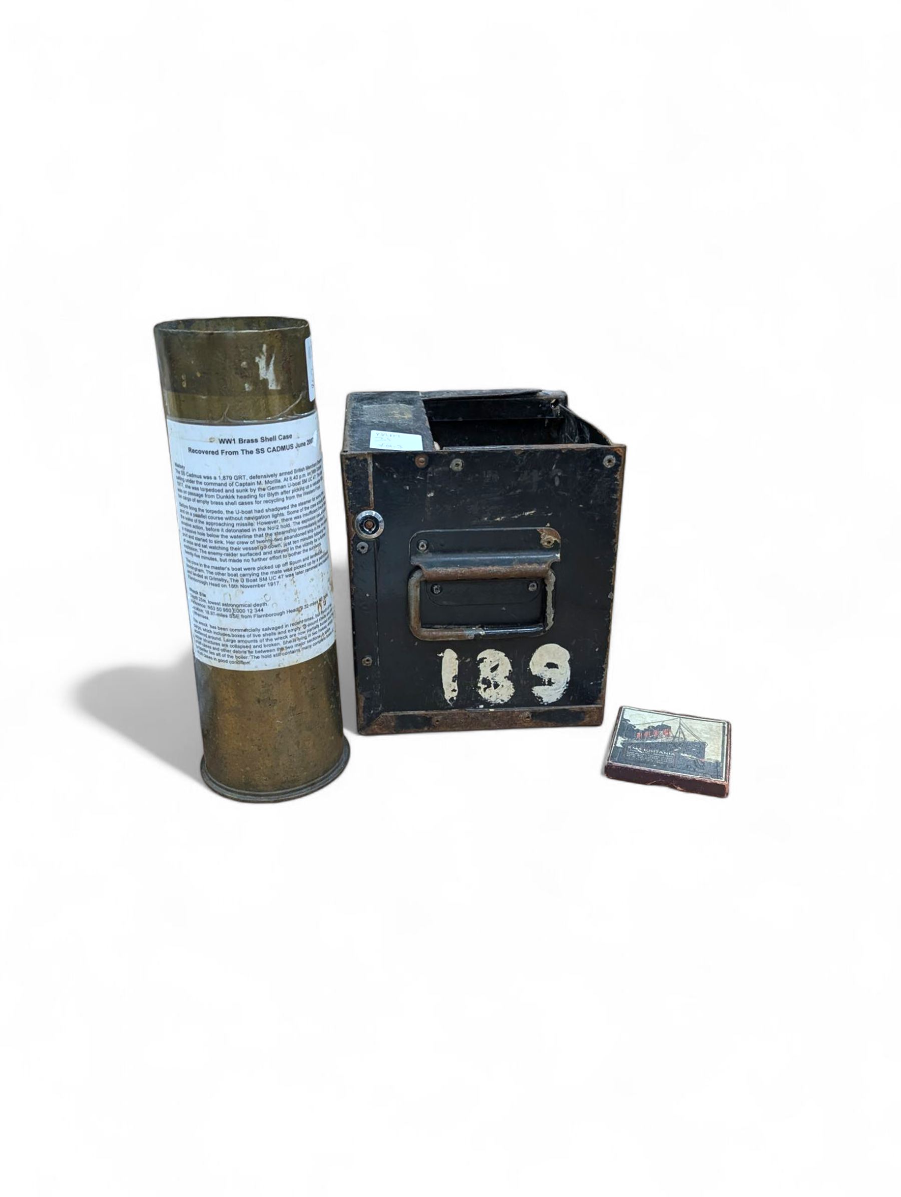 WWI brass shell case, by vendor repute salvaged from SS Cadmus wreckage site June 2007 off Flamborough Head, together with a reproduction RMS Lusitania medal in box and a metal tin