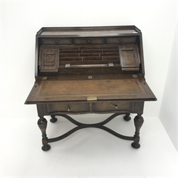  Early 20th century oak bureau, retracting fall front enclosing fitted interior above two drawers, turned support on 'X' shaped stretchers, W94cm, H109cm, D53cm  