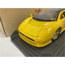 Two Maisto 1:12 scale cars comprising 1992 Jaguar XJ220 Racing car in yellow and 1992 Jaguar XJ220 in metallic green, both on plinths with original boxes