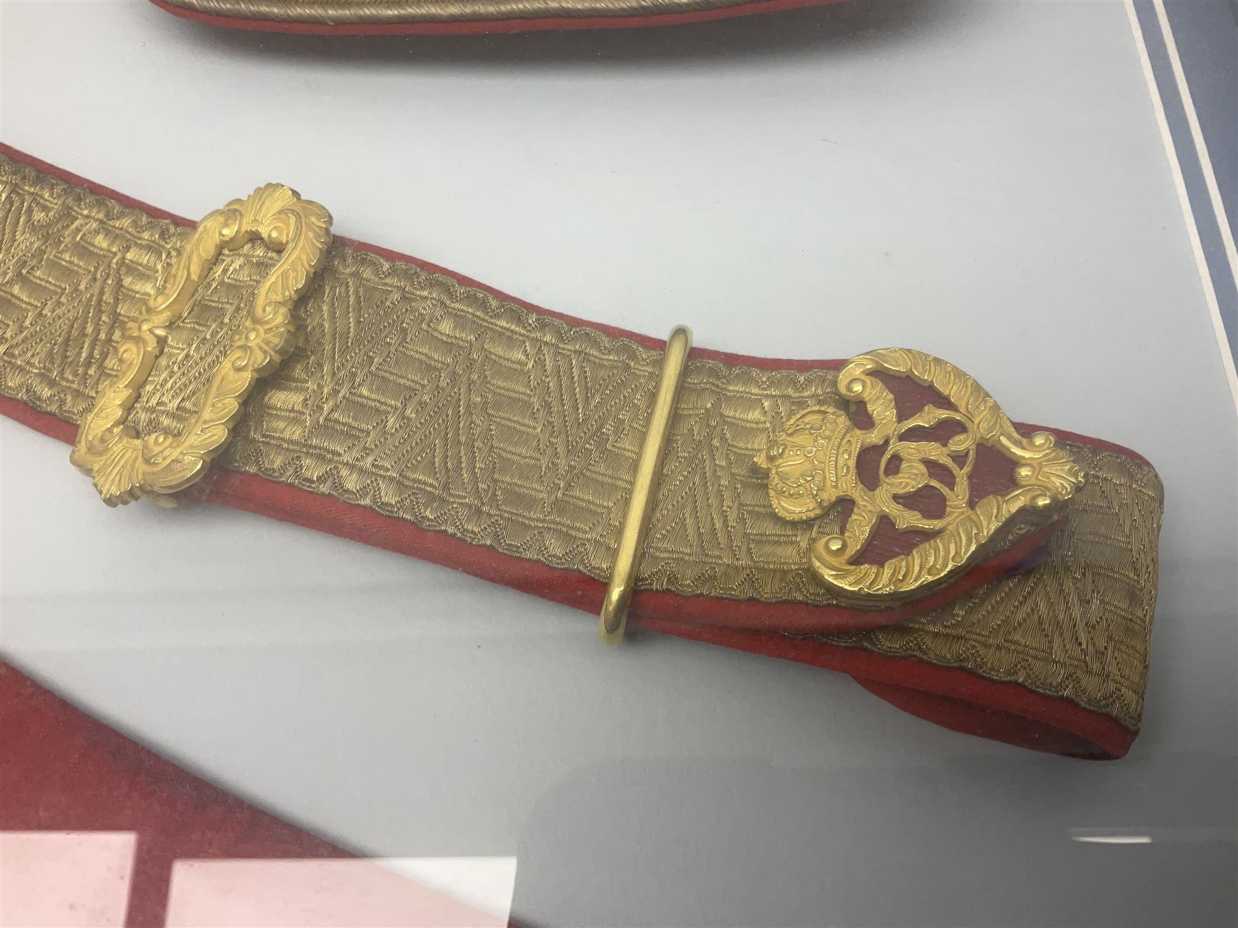 Victorian / Edward VII Queens Own Hussars Officers Full Dress Pouch and Cross Belt; scarlet cloth covered leather pouch with bullion embroidered crown, laurel bordered regimental crest within an edge of embroidered bullion wire; with its original officers cross belt with fine regimental pattern brocade to the top and gilt metal furniture; displayed in a wall hanging case with cloth and metal regimental badges; mahogany stained frame 44 x 54cm