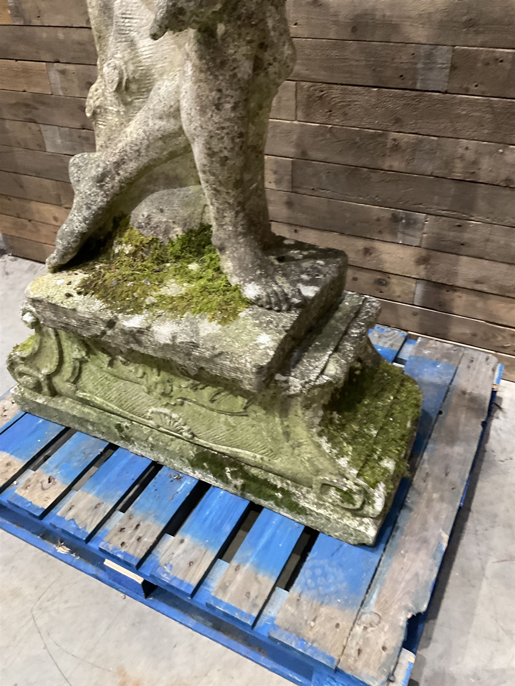 Life-size weathered cast stone Greek Discus Athlete, seated on rectangular slab raised on associated architectural plinth