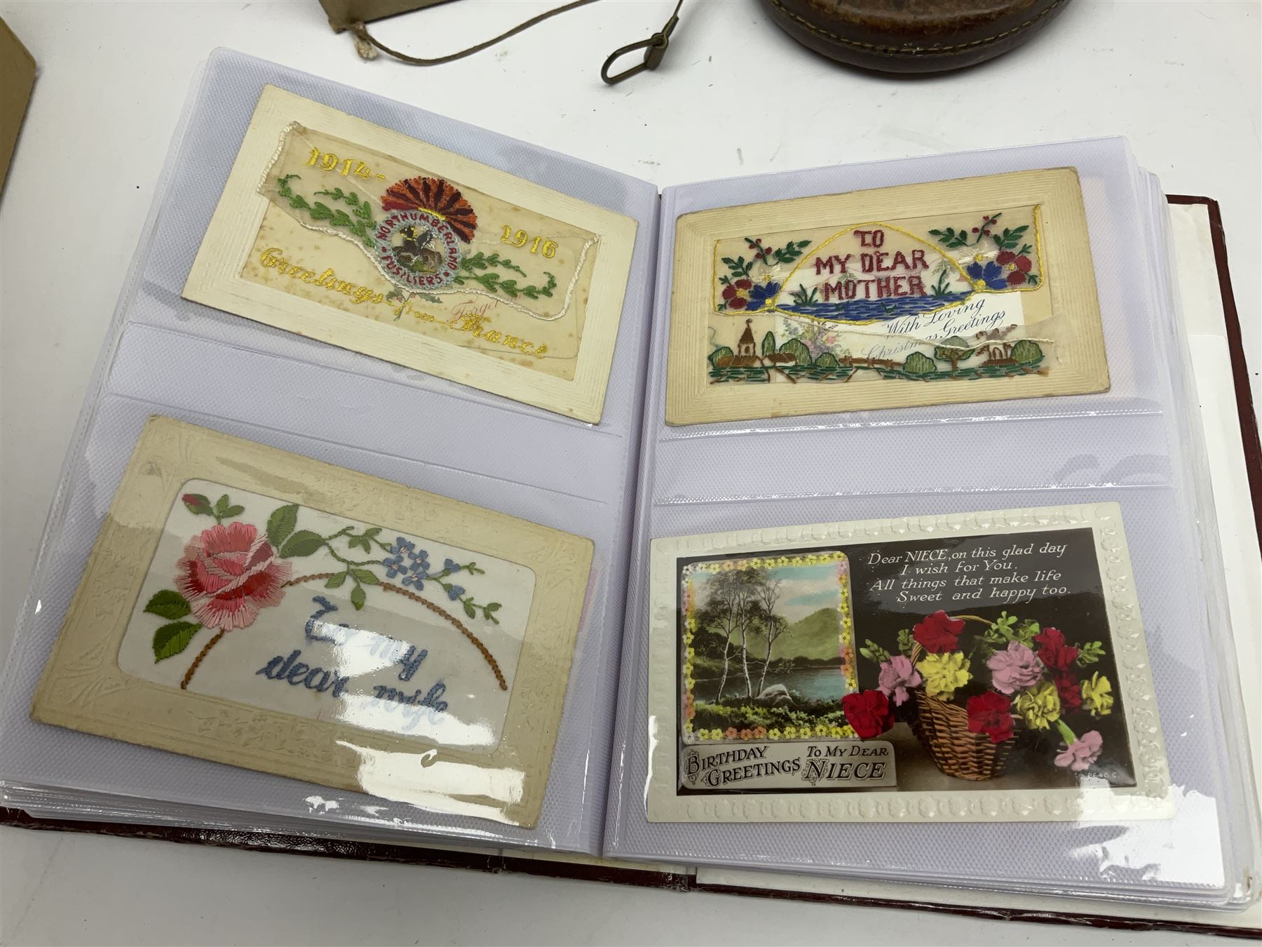 Postcards including WW1 silk postcards, local interest and photographic postcards, gas mask in box, material tape measure and metal sign. 