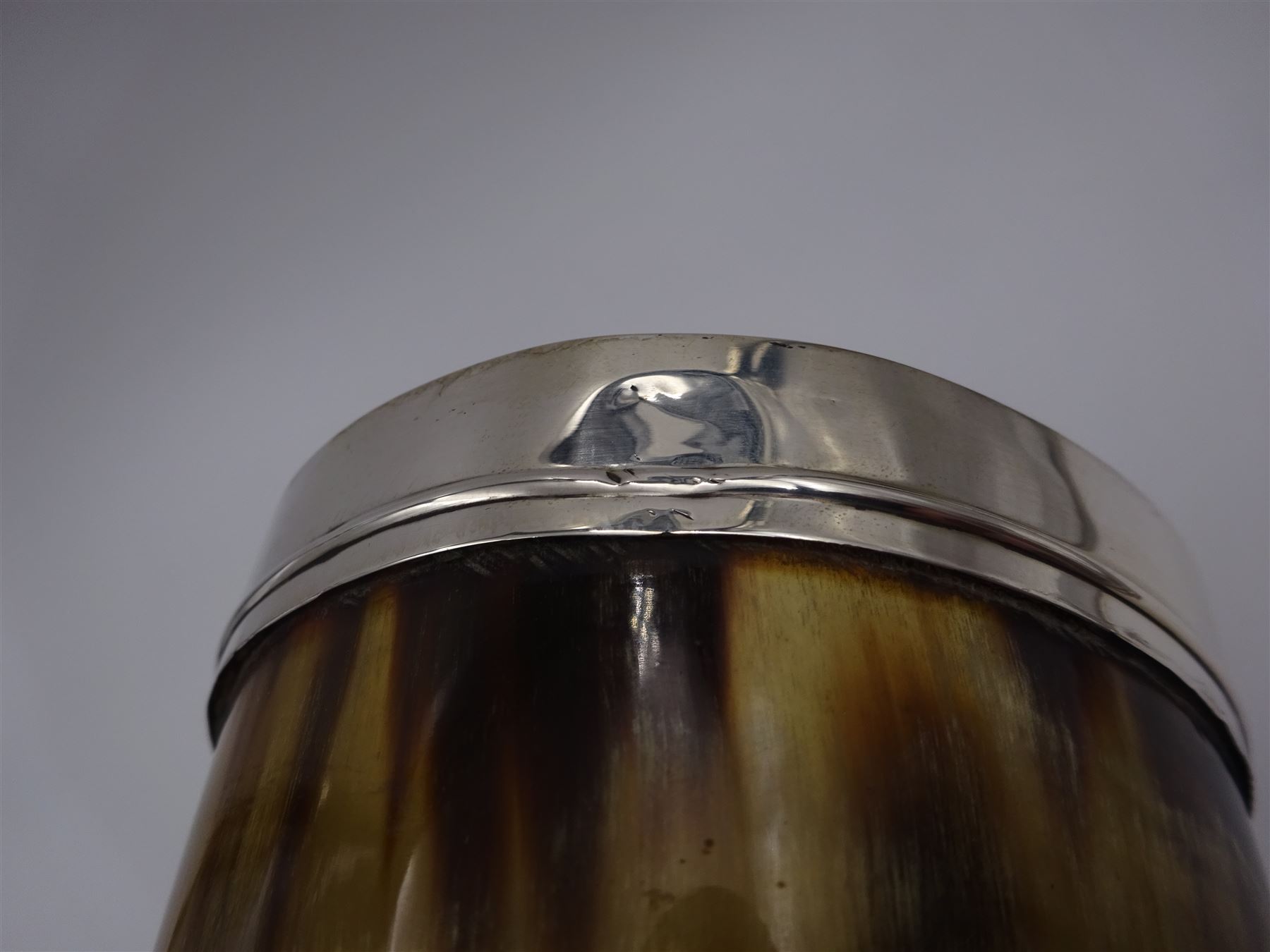 George III silver mounted horn cup, of tapering circular form, with polished exterior, the silver mounted collar hallmarked London 1808, no visible assay or makers mark, H13.5cm