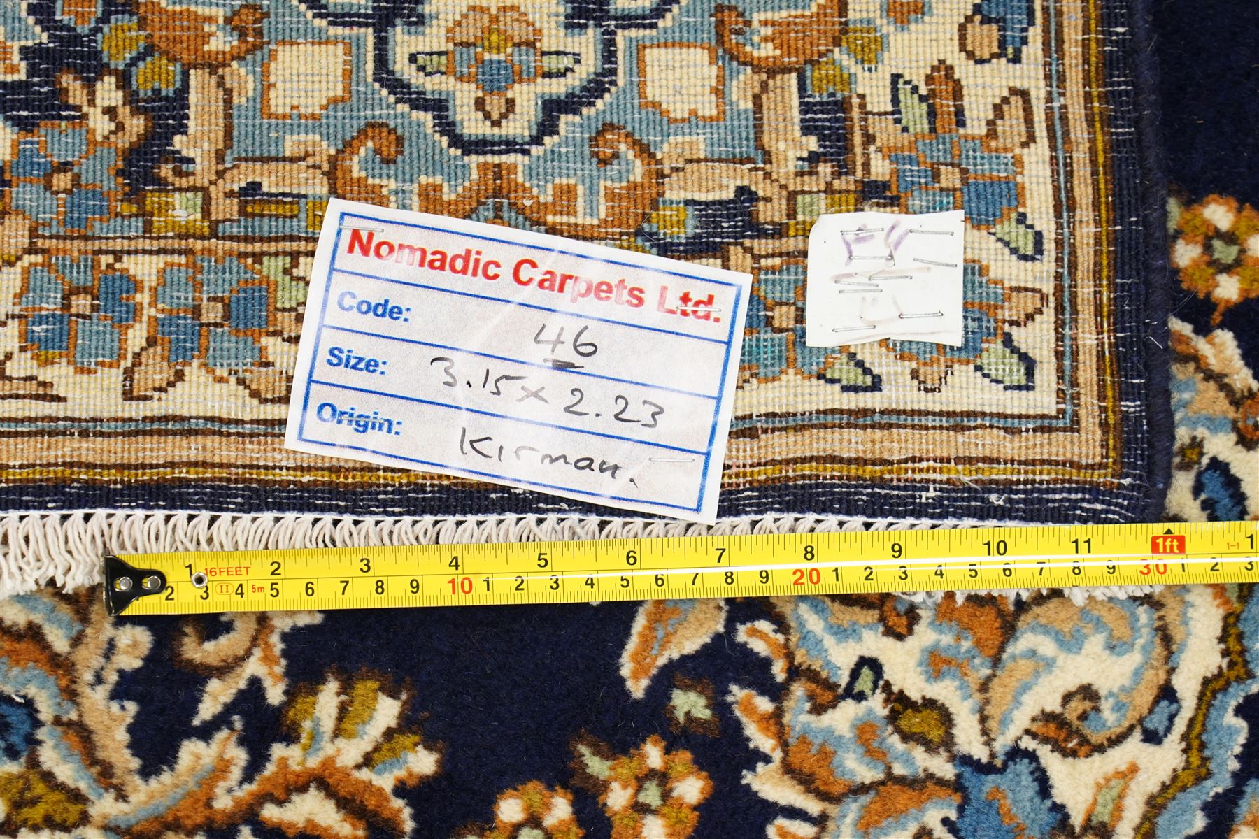 South East Persian Kirman hand-knotted carpet, indigo blue field with central floral medallion in tones of ivory, indigo,  and soft blue, issuing network of scrolling vinery, palmettes and floral sprays, conforming spandrels, broad main border of scrolling foliage and stylized palmettes, framed by multiple guard borders, with cotton fringe ends 