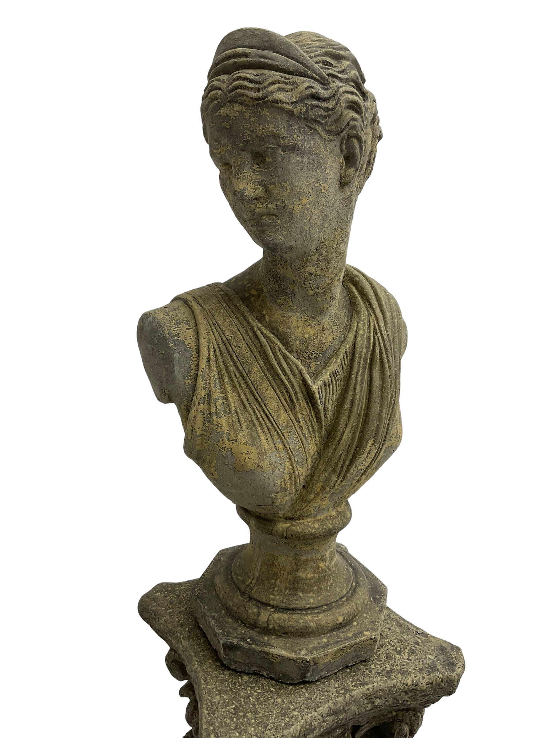 Classical design cast stone female bust depicting Artemis, raised on fluted Corinthian column with acanthus leaf capital, stepped square base, looking right 