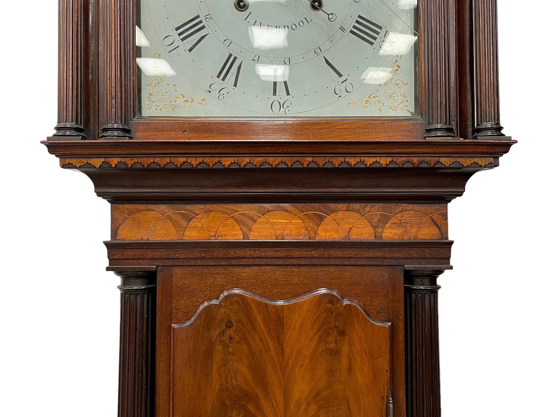 Penlington of Liverpool – early 19th century 8-day mahogany longcase clock, swans neck pediment with three turned wooden finials and verre eglomise panels, trunk with reeded columns and wavy topped door, plinth with canted corners on bracket feet, painted break-arch dial with Roman numerals and five-minute Arabic’s, centre sweep calendar and seconds hands, blue steel serpentine hands, signed beneath a painted rolling moon in the arch PENLINGTON, LIVERPOOL, eight day four pillar movement, anchor escapement and rack striking on a bell. With pendulum and weights.  The Penlington family were prolific clockmakers in 19th century Liverpool working from several addresses in the city, also recorded as chronometer and chronograph makers.