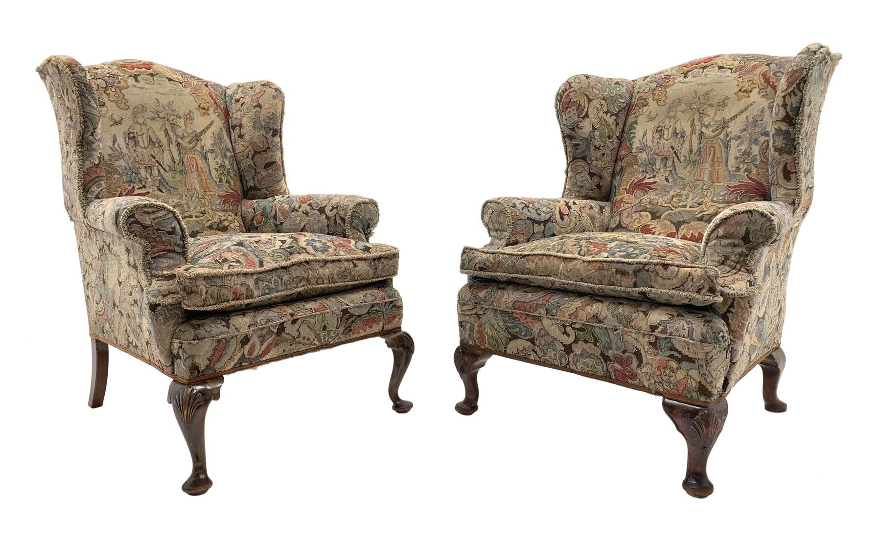 Matched pair early 20th century Queen Anne style wingback armchairs, walnut framed, sprung seats with seat cushions upholstered in needle work cover, shell carved cabriole front feet