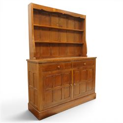 Cat and Mouseman - adzed oak dresser and plate rack, plate rack with two delf rack, panelled back and shaped uprights, above a base with two short drawers and turned wooden handles, panelled cupboard doors and sides, raised on a plinth base, with carved Cat and Mouseman signature, by Lyndon Hammell of Harmby