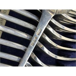 Late 19th/early 20th century composite canteen of silver flatware, contained within an early 20th century mahogany serpentine fronted case with twin drop carry handles, and hinged cover with boxwood stringing and central inlaid shell motif, above a single drawer with twin ring handles and Wellington style locking system, the cover and drawer opening to reveal plaque for Spink & Sons Ltd London, and fitted interior containing ivory handled knives, ivory handled carving set, and silver Hanoverian and Old English pattern cutlery, each with engraved monogram to terminal, hallmarked London, makers Spink & Son (John Marshall Spink), Goldsmiths & Silversmiths Co, and Chawner & Co (George William Adams), various dates ranging 1880-1923, gross weighable silver 92.59 ozt (2880 grams)