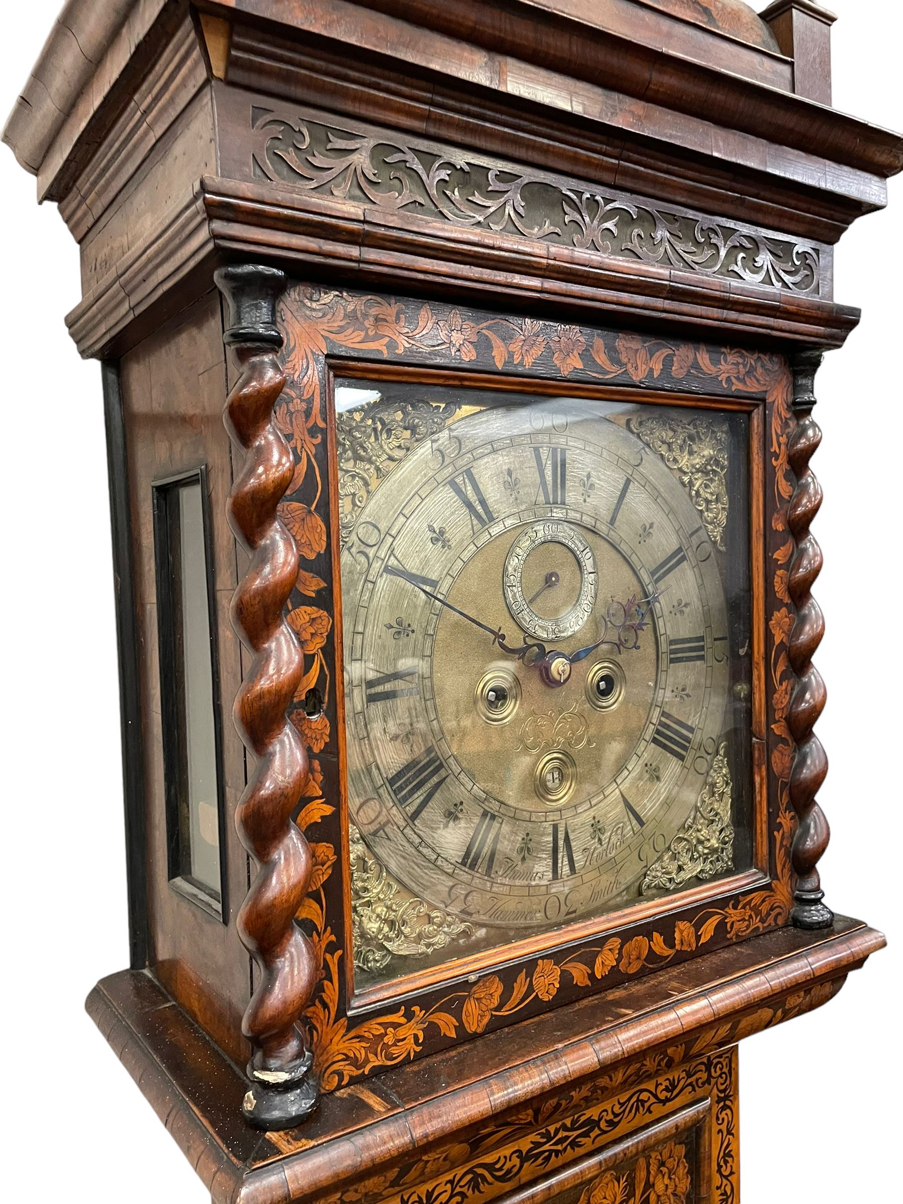 William & Mary floral marquetry 8-day longcase clock c 1700, later mid-18th century four pillar rack striking movement with a square brass dial and subsidiary seconds dial, ringed winding holes and calendar aperture to the matted dial centre, with London cherub head cast spandrels and (later) fretted steel hands, silvered Roman numeral chapter ring with stylised fleur di Lis half hour makers, narrow Arabic five-minutes, minute track and inner quarter hour track, signed Thomas Horlock, Hammersmith, 
case with box upstand to the domed floral marquetry decorated caddy with three brass flame finials, above a moulded cornice and fretwork frieze,  inlaid hood door with attached barley twist pillars to the front above an inlaid convex moulding, full length D moulded trunk door with a circular lenticle inlaid with floral and foliage panels inhabited with birds, on a conforming marquetry plinth with applied double skirting. Thomas Horlock is recorded as a Whitesmith & Clockmaker of Hammersmith, Middlesex.
A copy of Thomas Horlock's will dated the 15th June 1757 is held at The National  Archives Kew.