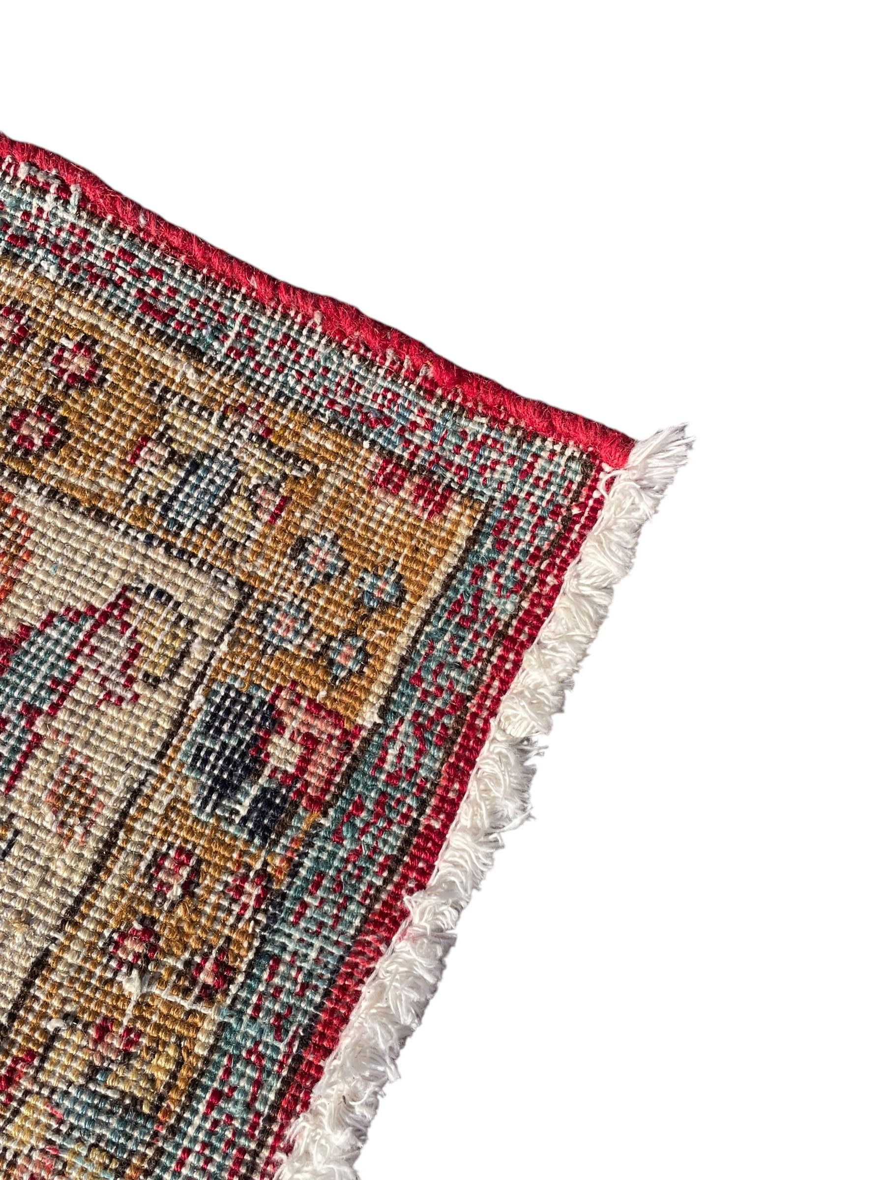 Persian Tabriz crimson ground rug, the field decorated with large palmette and stylised plant motifs connected by interlaced leafy branches, trailing border decorated with similar palmette motifs within floral pattern guard stripes, with signature panel 