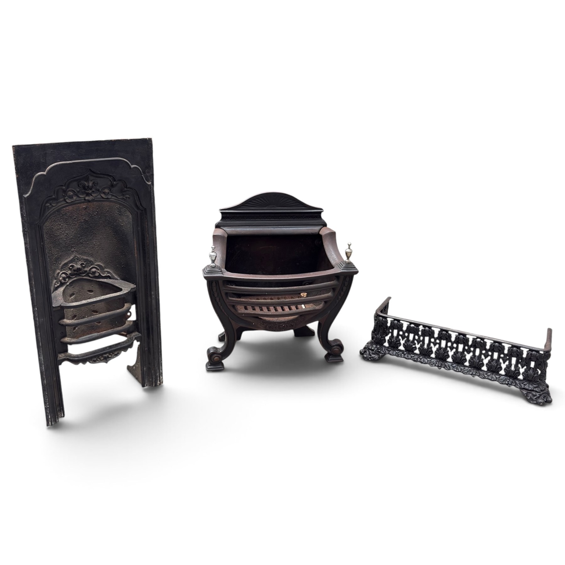 Three cast iron fireplace fittings, comprising a Regency-style fire grate with sunburst crest, urn finials, bowed basket and scroll supports (W58cm H63cm); Victorian fender with pierced acanthus frieze and foliate base (W64cm H20cm); Gothic Revival fireplace with fleur-de-lis crest, arched surround and integral fire basket (W41cm H87cm)