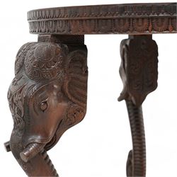 Anglo-Indian hardwood occasional table, circular top carved with concentric pattern and scrolling foliage, on three elephant carved supports decorated with flower heads