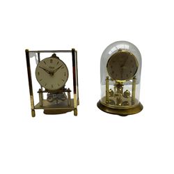 A 20th century English Torsion clock marketed by Bentime Ltd, London, with a four-ball rotary pendulum, white dial with gilt Arabic numerals and pierced gilt hands, under a glass dome, base with adjustable feet. No key.
Bentime Ltd did not make clocks but marketed clocks made by other companies such as J D Francis and Perivale.
H17
With a German Kundo torsion clock in a glazed rectangular case with four glass sides, four-ball rotary pendulum, white painted dial with gilt three-hour Arabic numerals and batons, with pierced brass hands. No key.
H15 W11 D9
