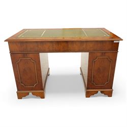 Late 20th century yew wood nine drawer writing desk, rectangular top inset with gilt-tooled green leather, above an arrangement of nine drawers with brass swan-neck handles, raised on bracket feet