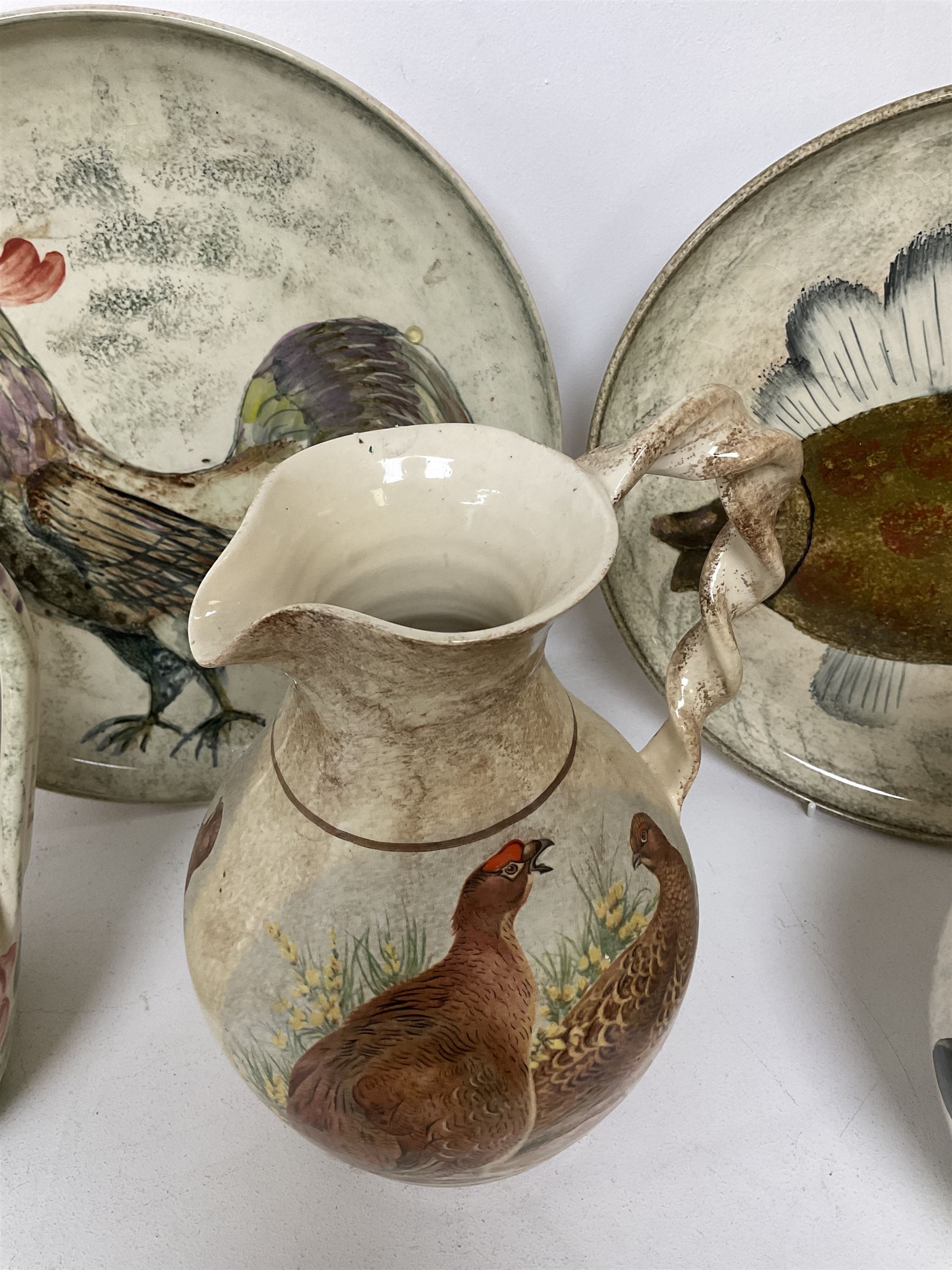 Collection of Yorkshire Moorlands Pottery, comprising two large circular dishes and three jugs, decorated with various fish, flowers, red grouse and cockerel