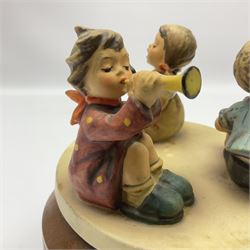 Three Hummel figure groups by Goebel, comprising Tuneful Trio, Travelling Trio and Trio of Wishes, together with Hummel Little Band music box, tallest H17cm 