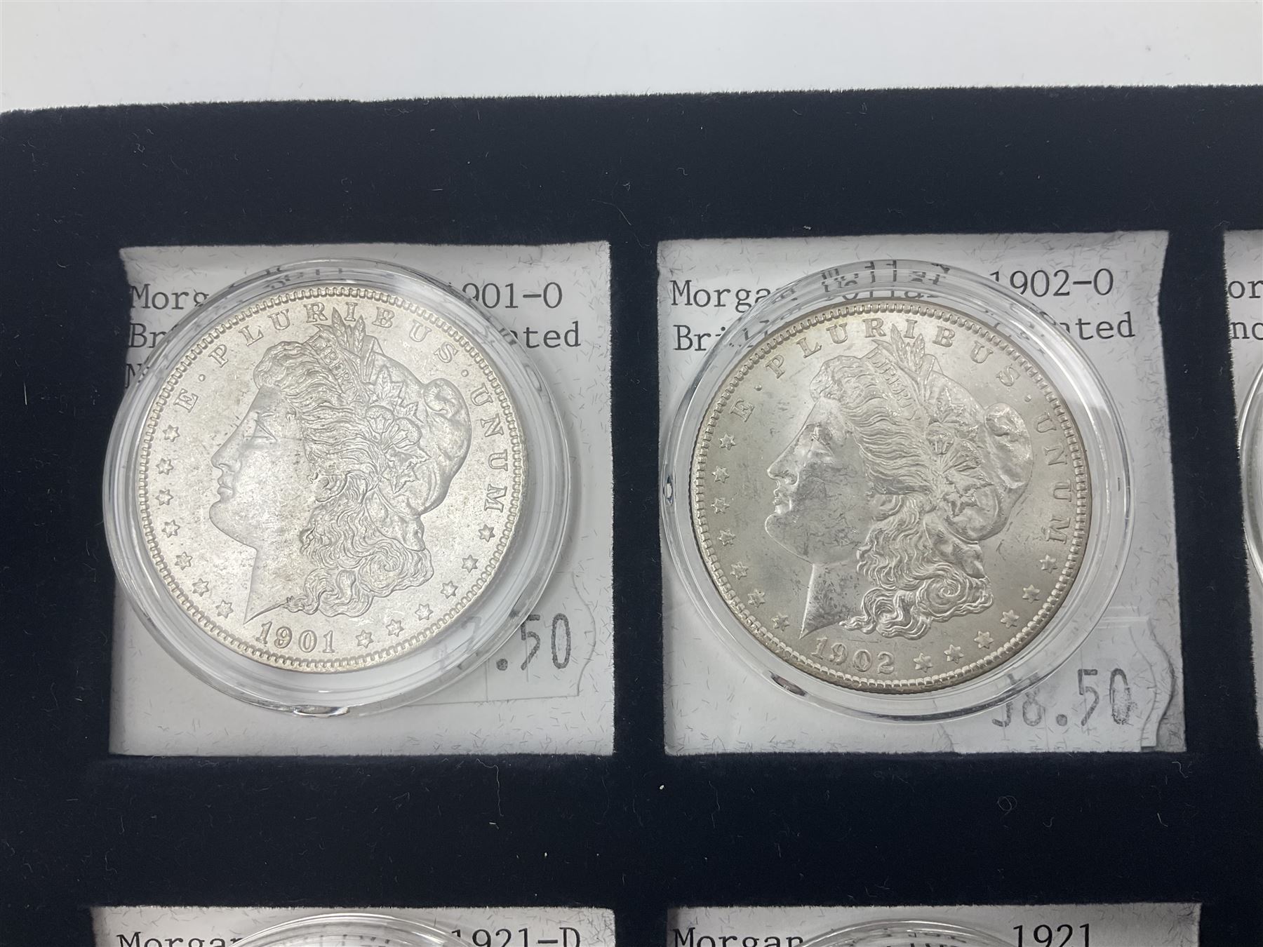 Seven United States of America silver Morgan dollar coins, dated 1884, 1901 O, 1902 O, 1903, 1904 O, 1921 D and 1921