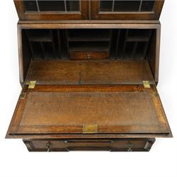 Early 20th century Jacobean Revival oak bureau-bookcase, astragal glazed doors enclosing two adjustable shelves, over geometric panelled fall-front enclosing fitted interior, over two drawers, raised on a spiral-turned base with barley-twist stretchers and compressed bun feet