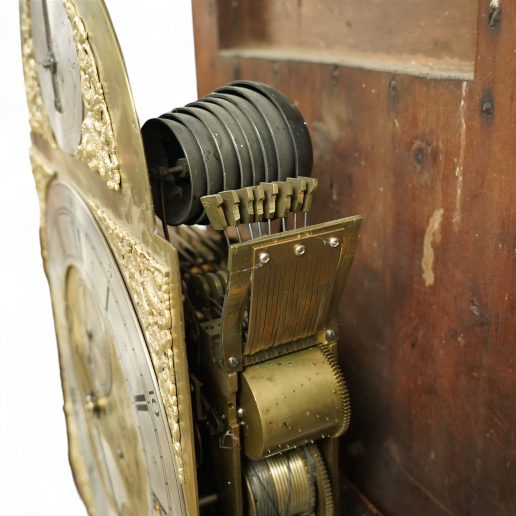 Lister of Halifax -  Oak cased musical longcase clock c1790, 8-day movement sounding the quarters and hours on bells or gong rods, case with a flat pediment and oval  conch inlay beneath, break arch hood door with reeded pilasters and brass Corinthian capitals, trunk with conforming quarter recessed pillars and a long wavy topped door, plinth with a raised panel and applied moulding the the base, break arch brass dial with cast spandrels and engraved dial centre, with a silvered chapter, seconds dial and cartouche with makers name, gongs or bells selector to the arch, chapter with Roman numerals, five minute Arabic's, minute track and steel moon hands, dial pinned directly to a three train weight driven movement with a nest of eight bells and eight gong rods, sounding the hours on either bells or gong rods, with a rack strike and recoil anchor escapement. With pendulum and weights.
The Lister family were a prodigious family of prolific clockmakers working in Halifax and the West Riding area of Yorkshire during the 18th and 19th century, well-known and noted for producing a number of chiming and musical longcase clocks.