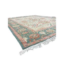 Persian Ziegler design carpet, pale ground field decorated with large stylised plant motifs, the border decorated with large floral motifs within repeating guards