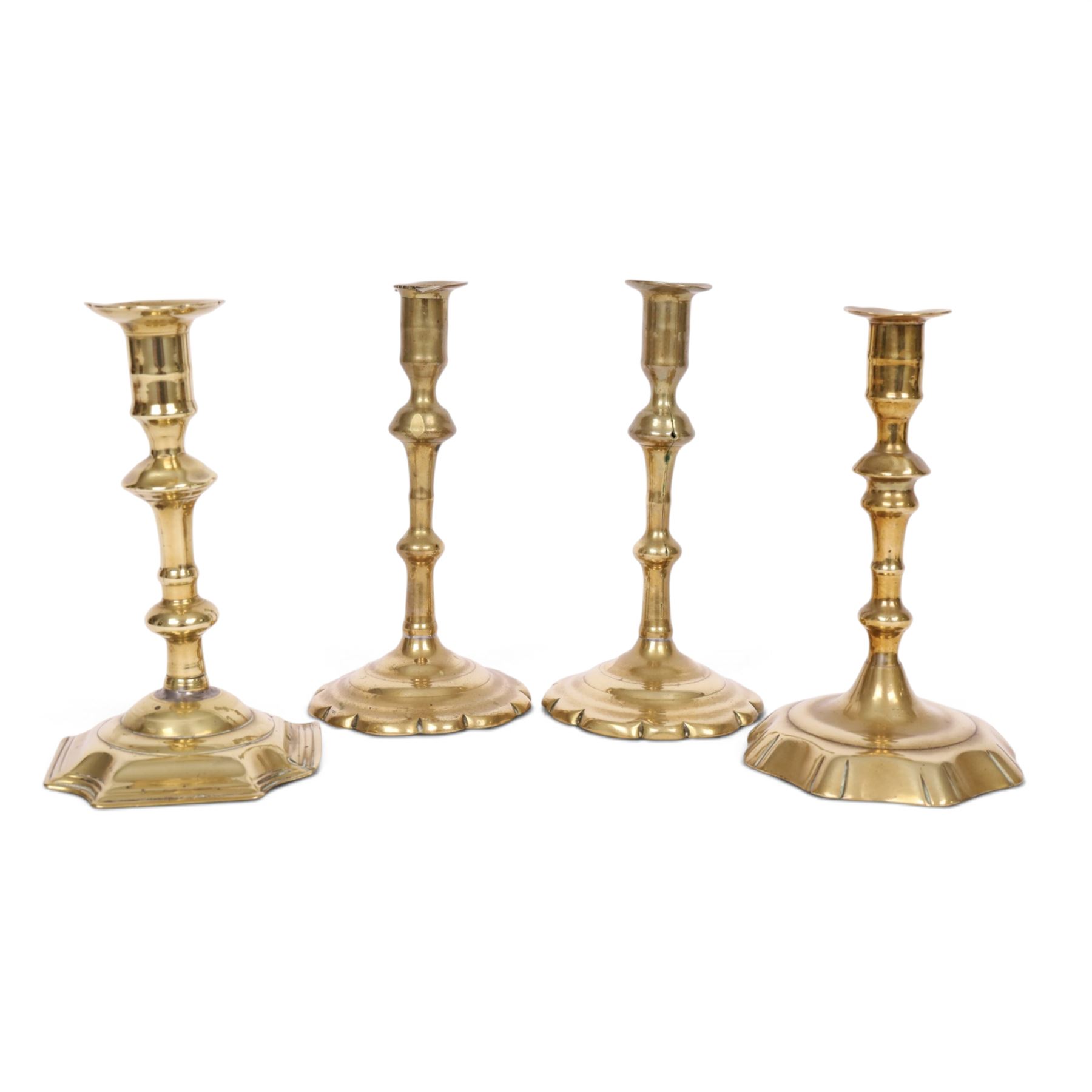 pair of 18th century brass candlesticks, each having slender knopped stems and scalloped petal base, together with two other brass candlesticks, H21cm