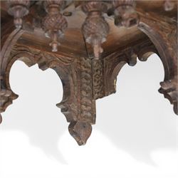 20th century Indian carved hardwood corner shelf, the tiered pagoda form with pierced and carved foliate panels centred by figural carving, supported by turned and carved columns, with shaped brackets and pendant finials