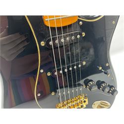 Copy of a Fender Stratocaster electric guitar in black with Wilkinson bridge, lock-in tuners, synchronised tremolo and various patent numbers; L99cm; in hard carrying case with strap and digital tuner