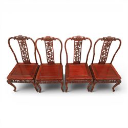 20th century Chinese ornately hardwood dining table and chairs, circular table with 'Lazy Susan' top with pierced carved frieze, raised on a quadriform base with carved foliate detail, the chairs en suite with carved pierced detailing  