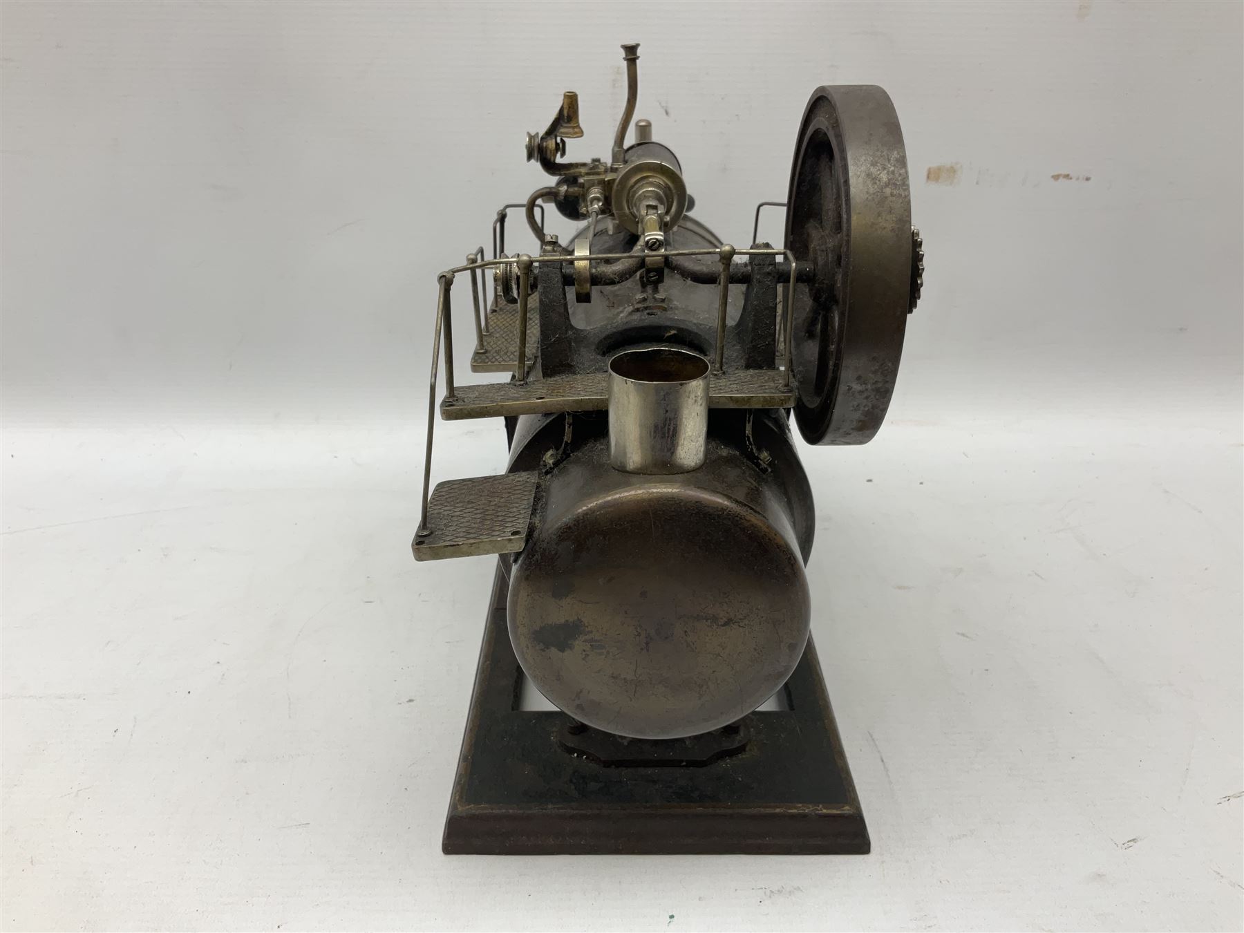 Stationary steam plant, probably early 20th century, the horizontal boiler with water gauge, whistle, safety valve, railed platforms and horizontal drive on top to 11cm flywheel; one cog marked Meccano; on oblong base L32cm