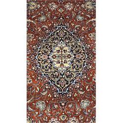 Central Persian Sarouk dark indigo and crimson ground rug, the medallion, field and spandrels decorated with repeating floral Herati motifs, the border decorated with scrolling branches and palmettes with small floral motifs, floral pattern guard stripes