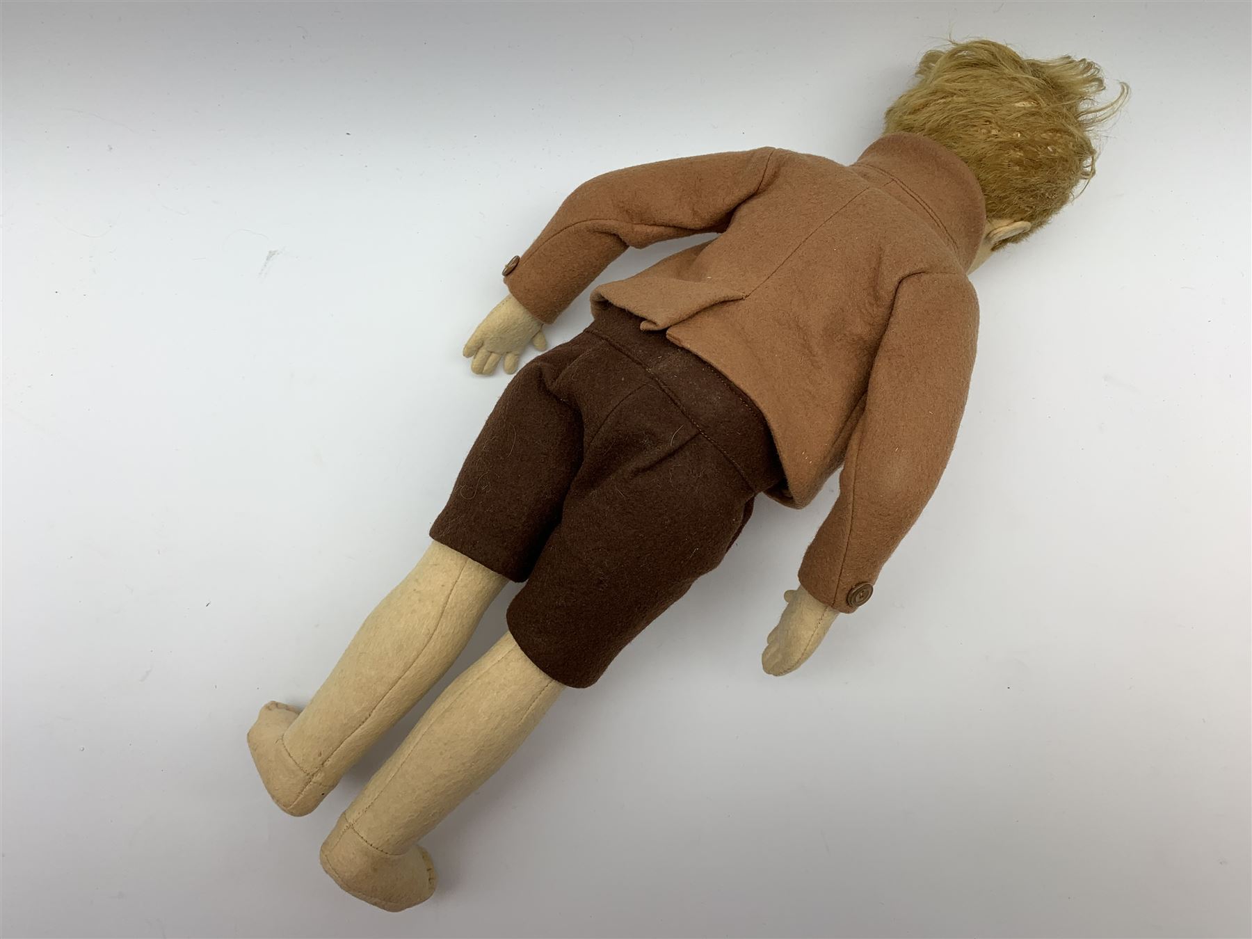 Lenci pressed felt boy doll c1930 the swivel  jointed head with blonde hair, painted side glancing brown eyes, smiling mouth with teeth, jointed body with stitched middle fingers, dressed in brown toned felt shirt, jacket and shorts H42cm