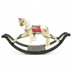 In the manner of F. H. Ayres - large carved wooden rocking horse, in dapple grey paint finish, decorated with glass eyes, leather reins, stirrup and saddle, on bowed rockers united by turned stretchers and boarded base 