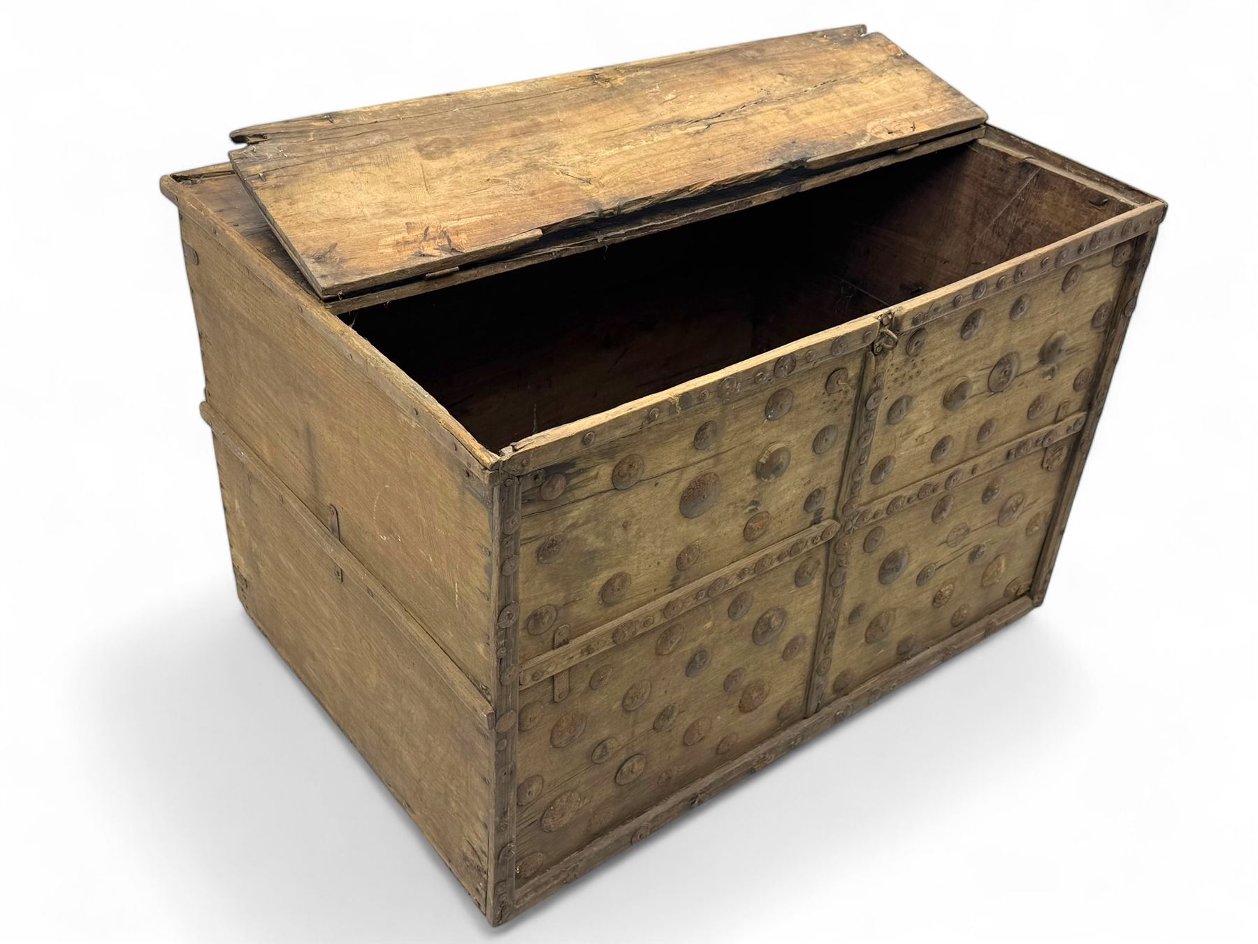 Late 19th century Afghan carved hardwood storage chest, the hinged plank top enclosing large internal storage space, geometric carvings to the front panels decorated with rows of riveted iron bosses
