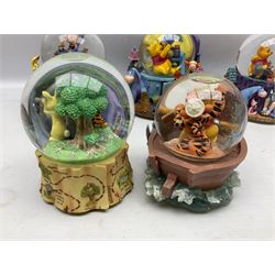 Five Disney Winnie The Pooh snow globes, to include Pooh and Piglet Sailing, Pooh's Grand Adventure and Blustery Day, together with The Walt Disney Classic Waterglobe collection globe and group Tigger, Winnie and Piglet figure under dome, all with boxes (7)
