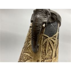 Pair of Bretby vases of tapering cylindrical form decorated with elephants, cranes and fishermen, the bodies with twin elephant mask handles, with coppered borders, raised upon three bun feet, stamped Bretby 2246 marks beneath, H32cm