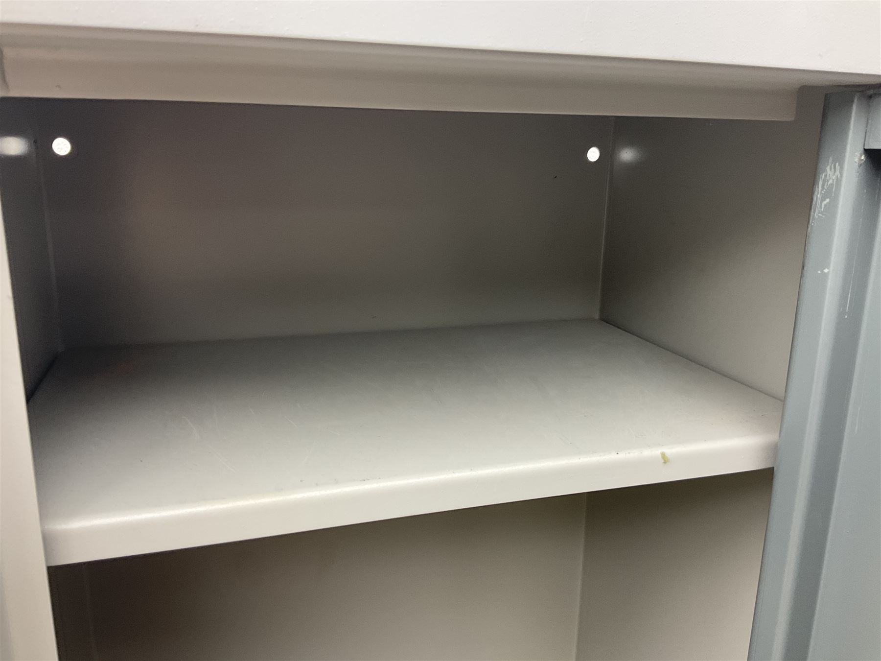 Two-tone grey steel wall-mounting gun cabinet by Sambell Engineering to accommodate six guns with fixed shelf over, gun space int. H132cm W36.5cm D23.5cm, the single double-locking door with two sets of keys, ext. H154cm W37cm D27cm