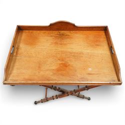 19th century coaching table, the rectangular tray top with shaped gallery and cut out carrying handles, raised on a folding X frame stand with turned supports and stretcher rails