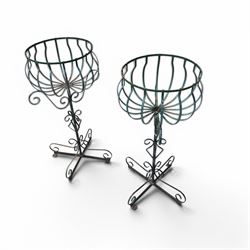 Matched pair of antique metal plant stands, each with circular strapwork basket tops, the scrollwork supports raised on an X-form base, in green painted finish with rustic patina