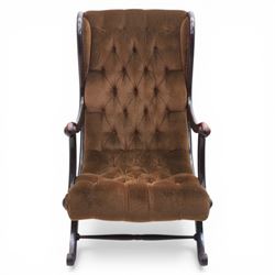 Late 20th century Regency style mahogany framed reading chair, the shaped and moulded frame with scrolled arms and open sides, upholstered in buttoned brown velvet, raised on curved supports terminating in scroll feet