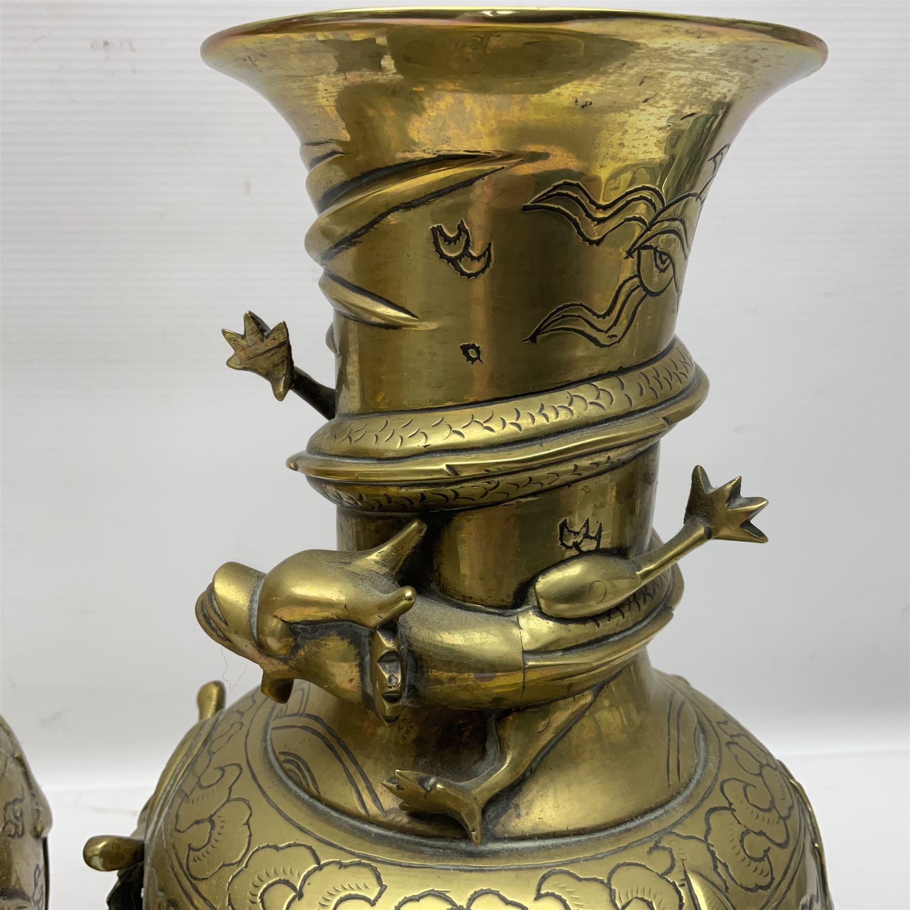 Pair of Chinese brass vases, of ovoid form with elongated neck and fluted rim, decorated in high relief with a dragon chasing a flaming pearl around the neck, the body with dragons, birds and buildings, with character marks beneath, H25cm