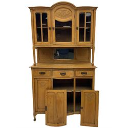 19th century elm dresser, the raised arched top enclosed by three glazed doors, the central door with floral carved panel, the base fitted with three drawers and three cupboards