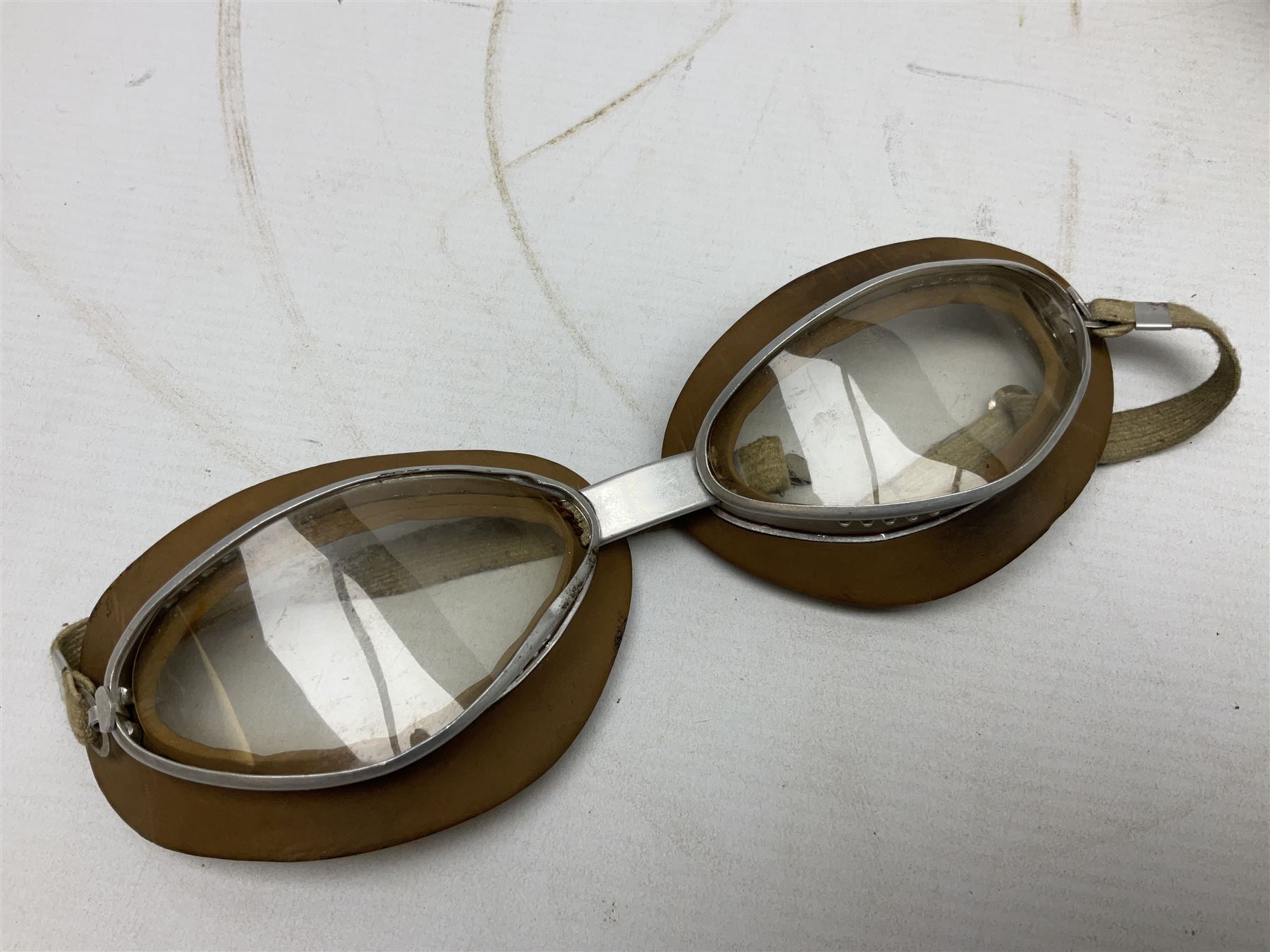 Two Geno Paris small size motorcycle helmets; and three pairs of goggles, one marked 'Stadium'