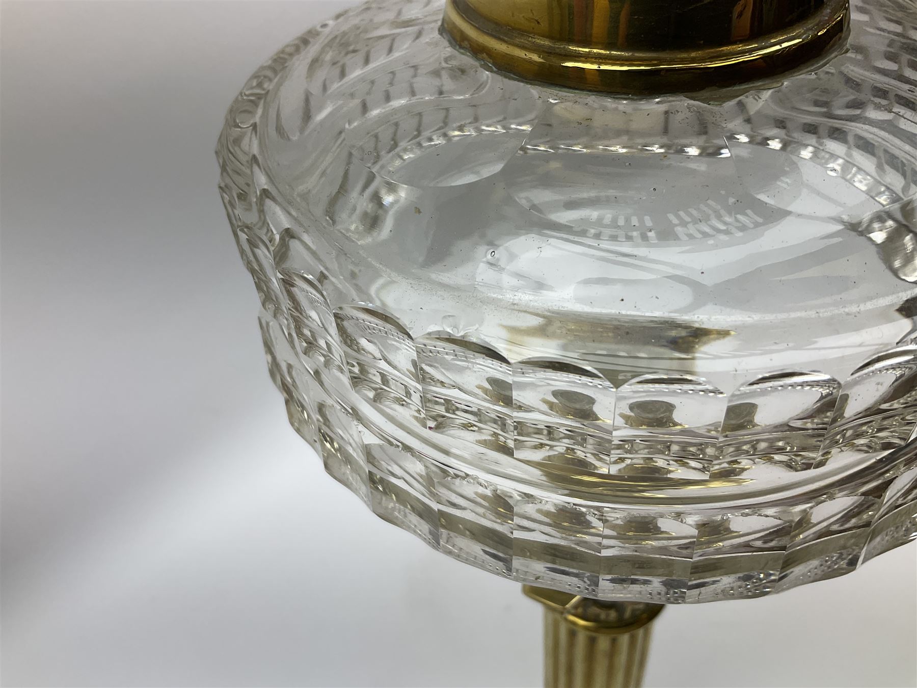 Victorian brass oil lamp, the square stepped base leading to a Corinthian column supporting a part slice cut clear glass reservoir, burner, clear glass chimney and foliate etched glass shade with amber rim, overall H80cm