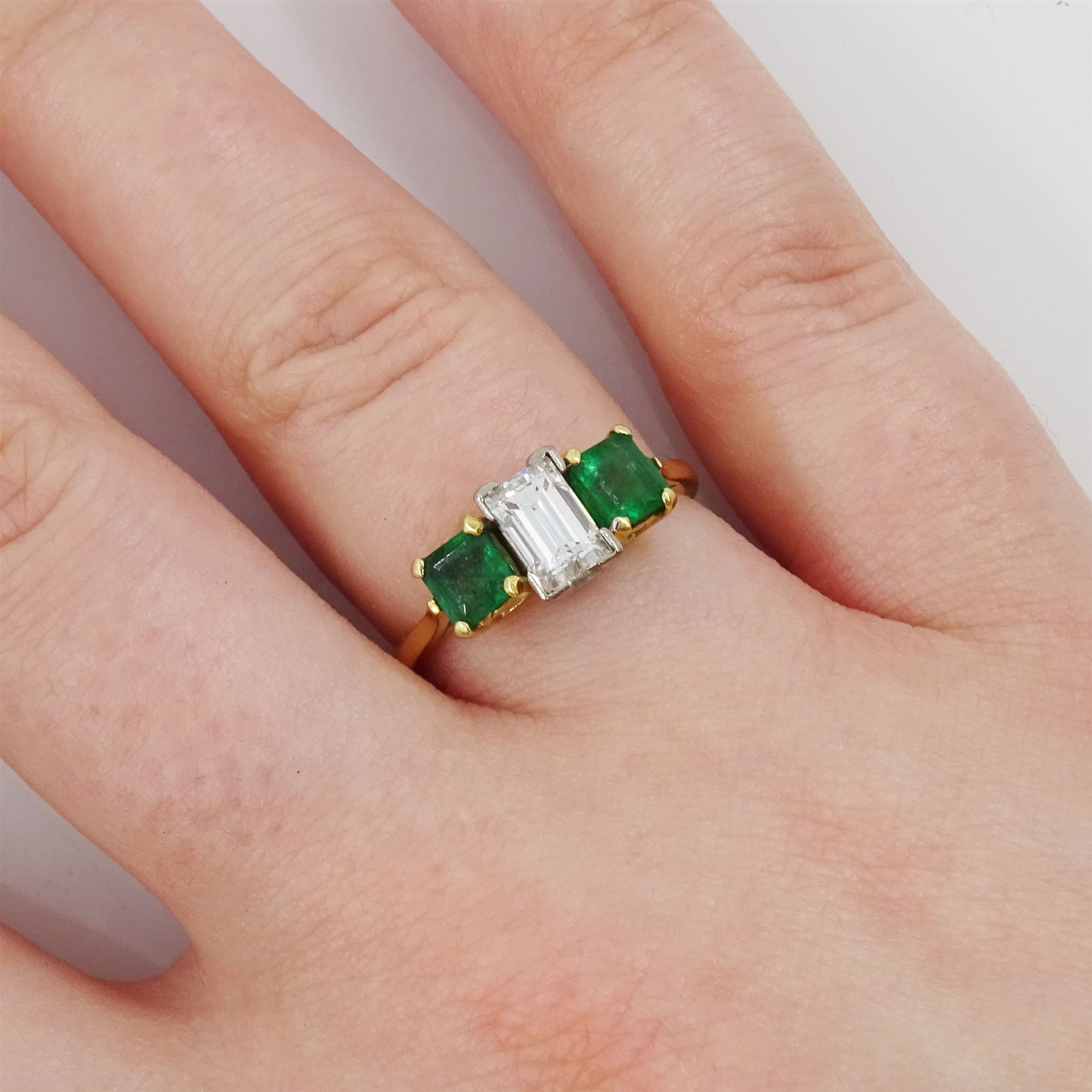 Gold three stone baguette cut diamond an square cut emerald ring, stamped 18ct, diamond approx 0.80 carat, total emerald weight approx 0.65 carat