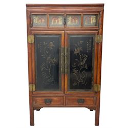 Late 19th century Chinese Qing dynasty red and black lacquered wood cabinet,  Fujianese province, upper cupboard enclosed by two doors with relief carved and gilt panels depicting figures behind glass, the large cupboard enclosed by two panelled doors carved with trailing foliate branches and birds, inscribed with Chinese characters, to the left ‘The red mountains are in the shape of Phoenixes and appear auspicious’ and to the right, ‘Wealth and honour are given by flowers and I hear the sound of the phoenix', fitted with two drawers, on square supports with carved brackets 