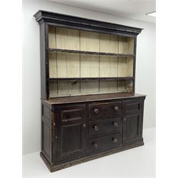 Early 19th century scumbled pine dresser, the projecting cornice over two heights plate rack with moulded frame, the base with reeded canted corners fitted with three drawers and two panelled cupboards, panelled sides, moulded skirt base